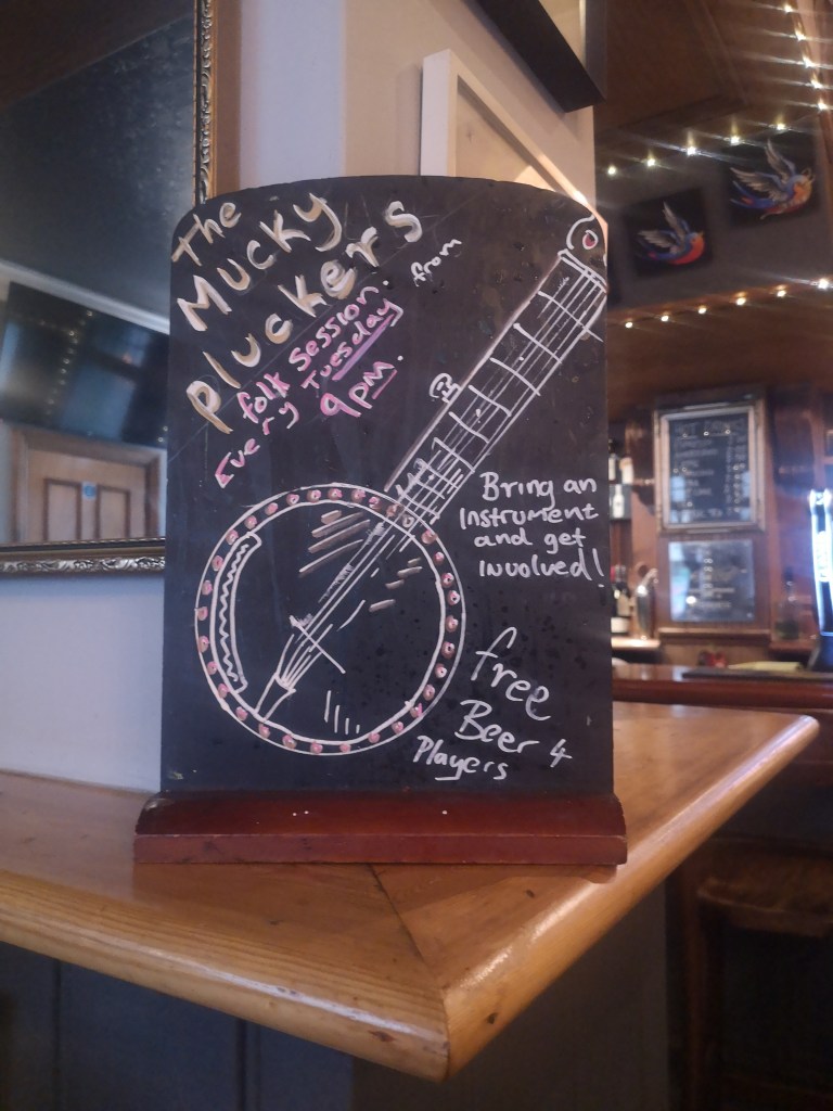 Handwritten sign promoting the folk session on Tuesday called The Mucky Pluckers